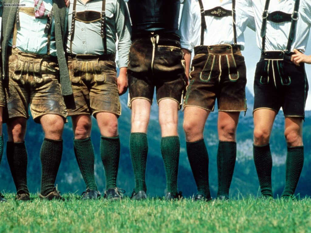 Five men standing in a row wearing traditional Bavarian Lederhosen and green socks. - Lederhosen For Sale