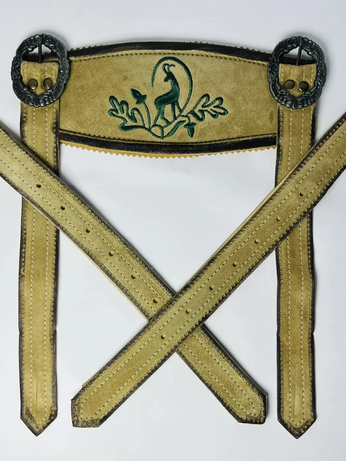 Full view of light gold handcrafted Oktoberfest Lederhosen H-shaped suede suspenders with green stag embroidery and dark silver buckles. - Lederhosen For Sale